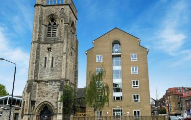 A multistory building next door to a church