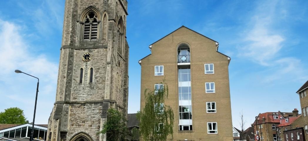 A multistory building next door to a church