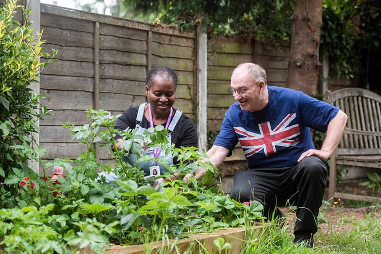 Staff and customer gardening together