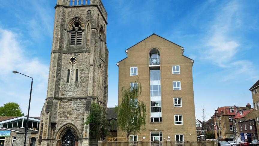 A multistory building next door to a church