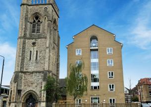 A multistory building next door to a church